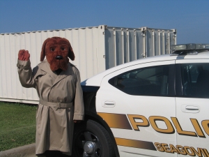 McGruff the Dog stands next to a police car